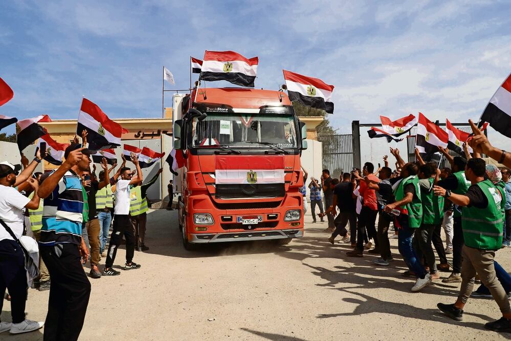 Los trabajadores humanitarios egipcios, al celebrar ayer mientras un camión cruzaba de regreso a Egipto a través del paso fronterizo de Rafah con la Franja de Gaza. Foto: Kerolos Salah / AFP