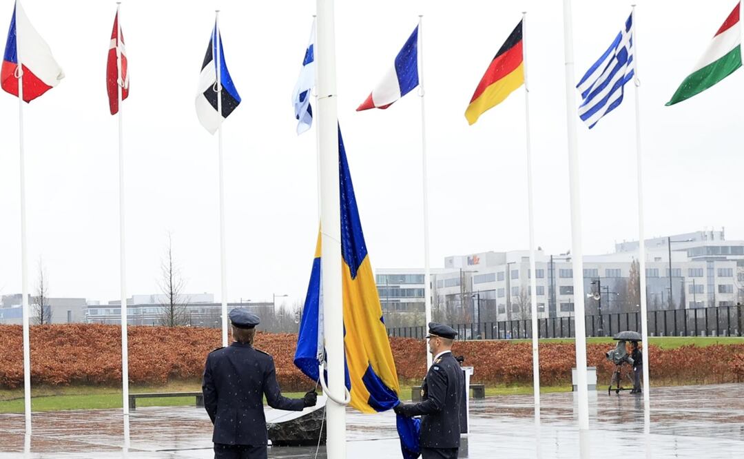 Dos militares se preparan para izar la bandera de Suecia en una ceremonia para conmemorar la entrada del país en la OTAN, en la sede de la OTAN. Foto: AP