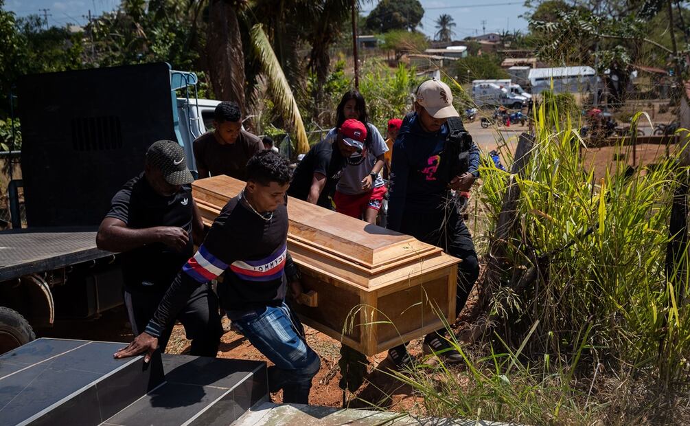 Un grupo de personas carga el féretro con una de las victimas mortales del derrumbe en la mina 'Bulla Loca' momentos antes de su entierro este jueves, en La Paragua (Venezuela). Foto: EFE