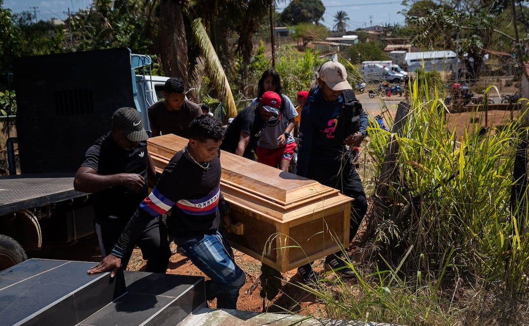 Un grupo de personas carga el féretro con una de las victimas mortales del derrumbe en la mina 'Bulla Loca' momentos antes de su entierro este jueves, en La Paragua (Venezuela). Foto: EFE