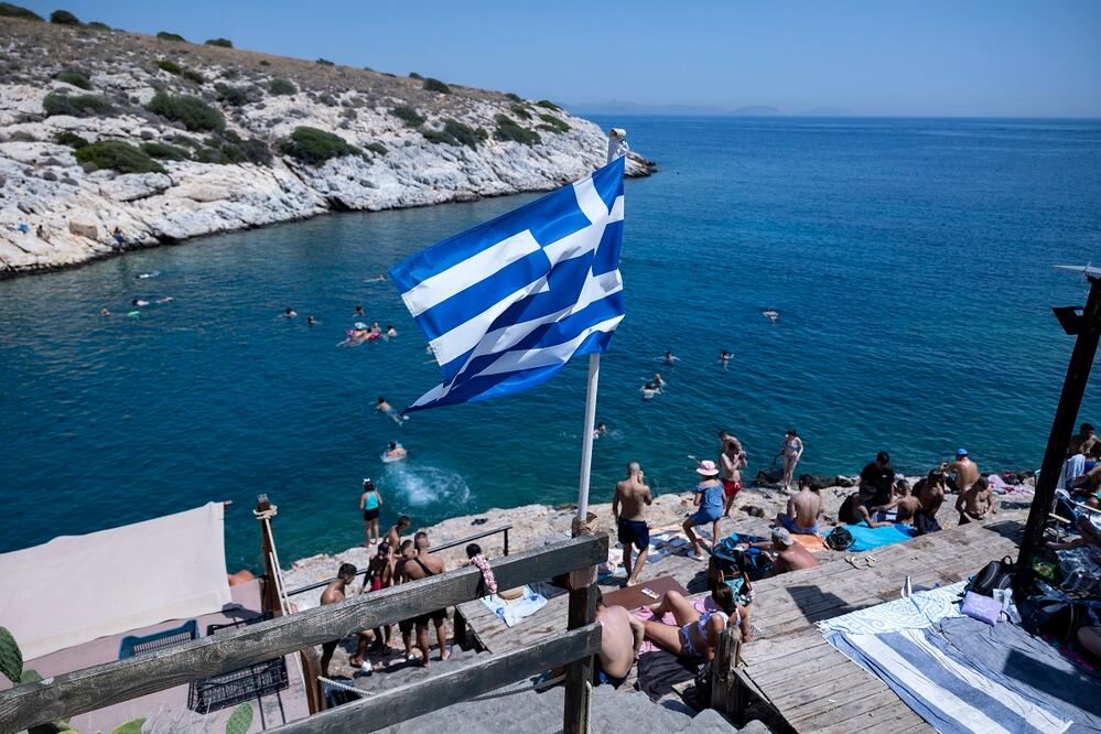 Bañistas, en las rocas junto al mar, en el suburbio de Vioulagmeni, al sureste de Atenas. En la isla de Rodas, los visitantes fueron evacuados. Foto: AP