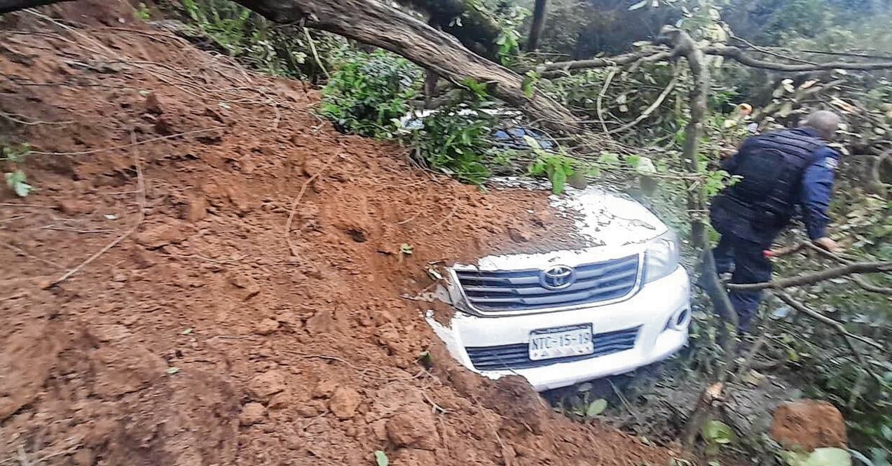 Integrantes de la Junta de Caminos quedaron atrapados y fueron rescatados ilesos por policías y elementos del Ejército. Foto Especial