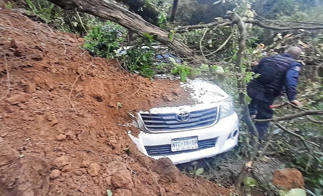 Integrantes de la Junta de Caminos quedaron atrapados y fueron rescatados ilesos por policías y elementos del Ejército. Foto Especial