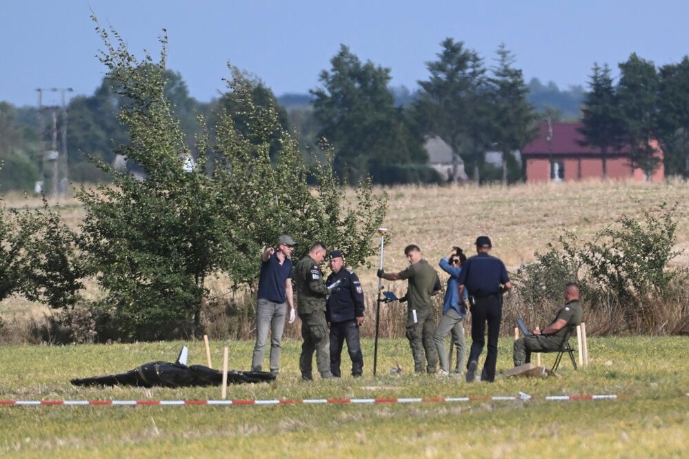 La policía y la policía militar protegen partes de un drondañado derribado por las autoridades polacas en un emplazamiento de Wohyn, Polonia. FOTO: AP