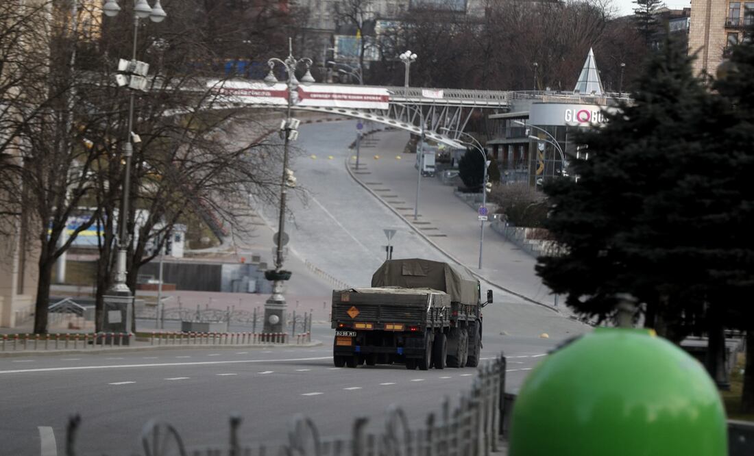 Imagen de un vehículo militar que cruza a un lado de la Plaza de la Independencia vacía en la ciudad de Kiev