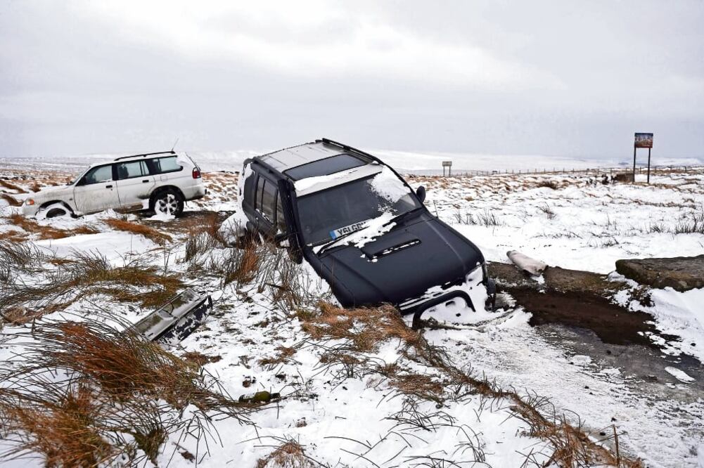 Vehículos abandonados se observan en la carretera A672, al noreste de Manchester, en el norte de Inglaterra, donde las nevadas están causando estragos. (OLI SCARFF. AFP)