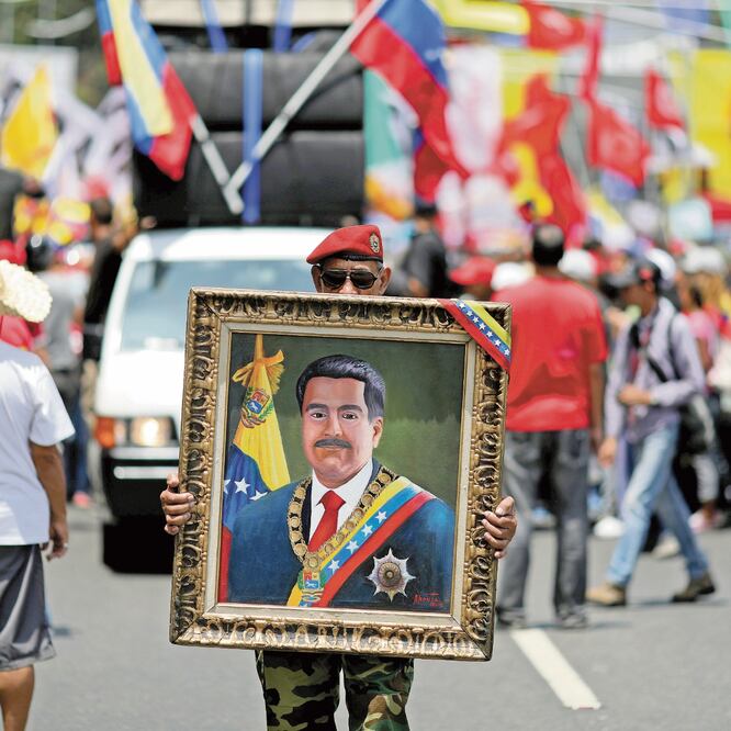 Un simpatizante del presidente venezolano, Nicolás Maduro, sostiene un cuadro con el retrato del mandatario, ayer en Caracas. MANAURE QUINTERO. REUTERS