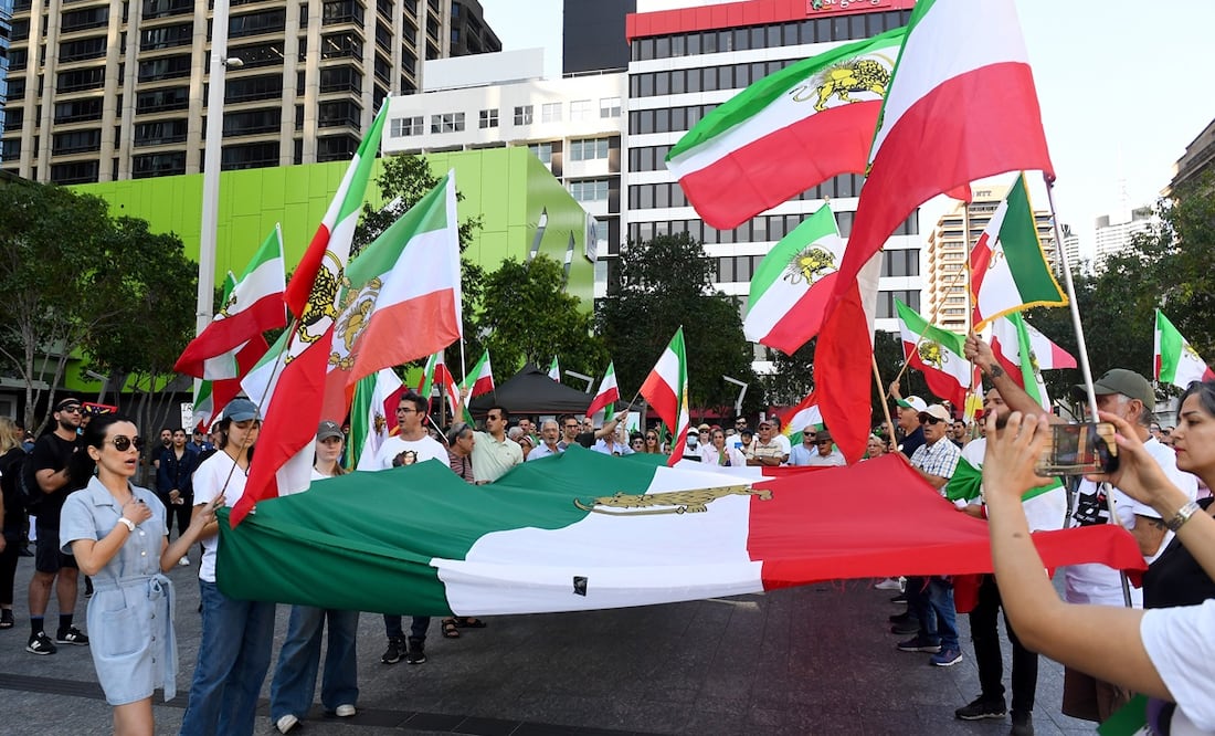 La gente sostiene banderas iraníes durante una manifestación, en Reddacliff Place, Brisbane, Australia, que conmemora el primer aniversario de la muerte bajo custodia de Mahsa Amini. Foto: EFE