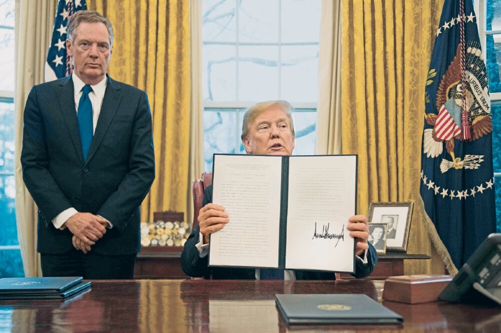 Acompañado de Robert Lighthizer, representante de Comercio de Estados Unidos, el presidente Donald Trump muestra el texto del acuerdo para imponer aranceles por tres años a lavadoras y paneles solares exportados a esa nación por México (JIM WATSON.AFP)