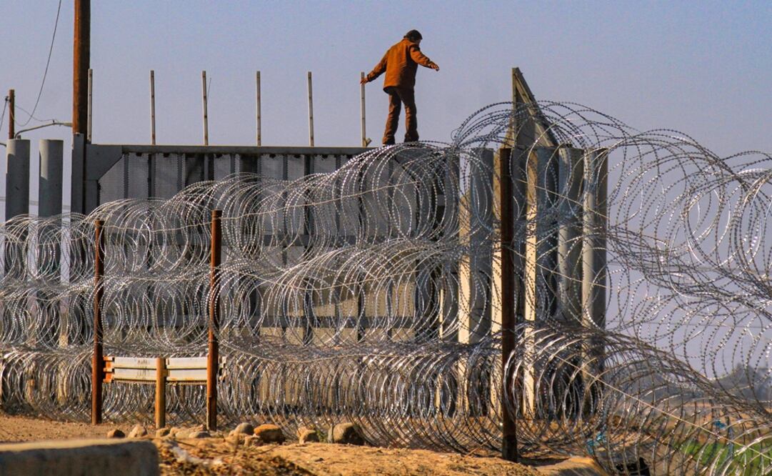 Una persona burla las alambradas de acero en Tijuana (Foto: EFE)