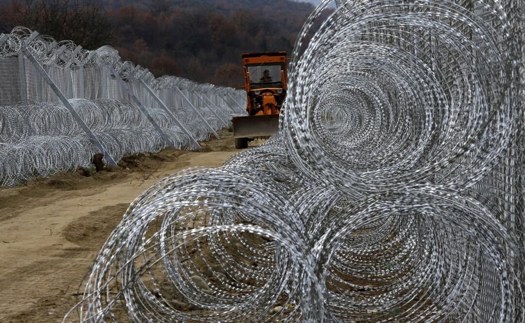 A front loader passes next to a double barbed wire fence - Photo: Ognen Teofilovski/REUTERS
