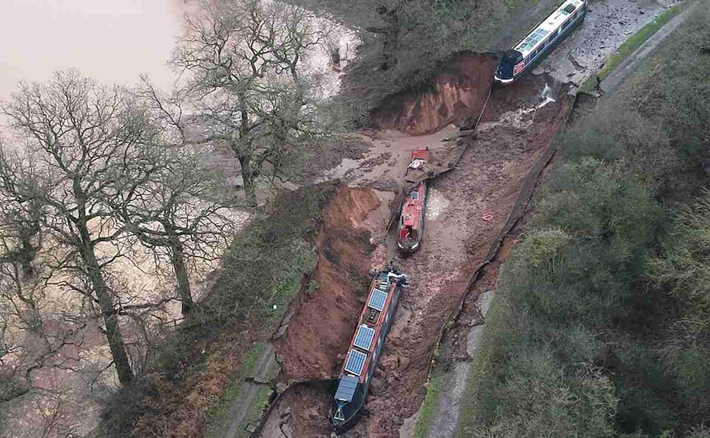 Esta foto aérea, tomada y difundida por el Servicio de Bomberos y Rescate de Shropshire el 22 de diciembre de 2025, muestra embarcaciones en el lecho del canal tras la formación de un socavón a lo largo del Canal de la Unión de Shropshire, que drenó el agua, en la zona de Chemistry de Whitchurch, Shropshire, en el centro de Inglaterra. Foto: AFP