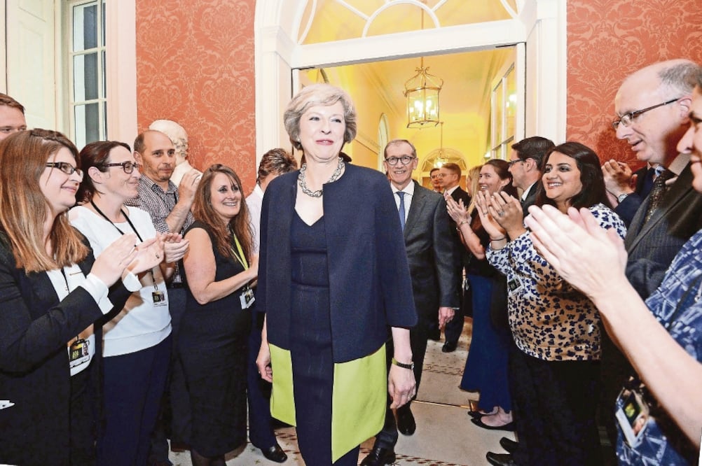 Personal aplaude a la llegada, ayer, de la nueva primera ministra británica, Theresa May, al 10 de Downing Street, en Londres (AP)