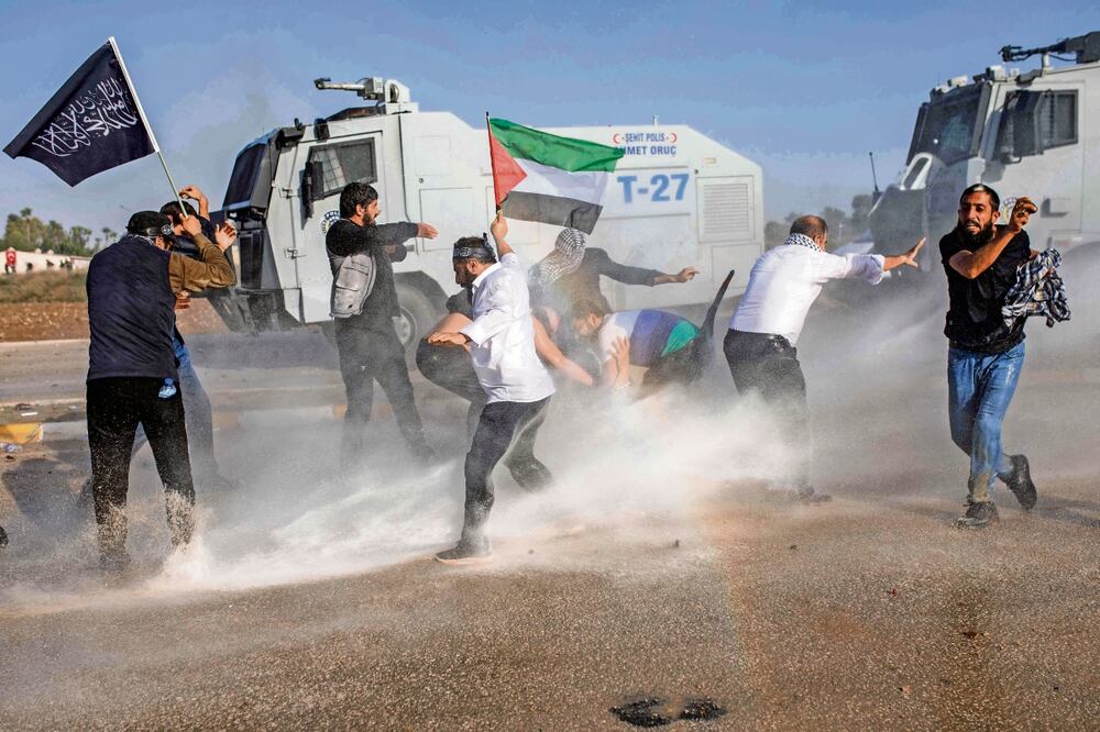 La policía turca dispersa con cañones de agua a manifestantes con la bandera palestina ,durante una protesta cerca de la base aérea de la OTAN en Incirlik, en Adana. Foto: Can Erok/AFP