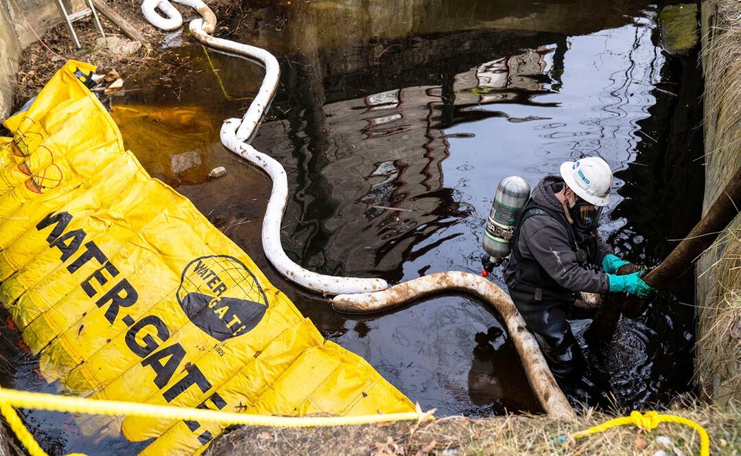 Un trabajador en un arroyo del centro de East Palestine, Ohio, tras el descarrilamiento de un tren. Foto: AP 
