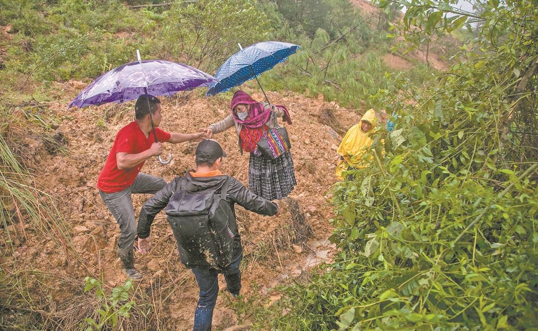 Pobladores cruzan a través de vías improvisadas por los derrumbes que dejó Eta en Guatemala. Foto: Esteban Biba. EFE