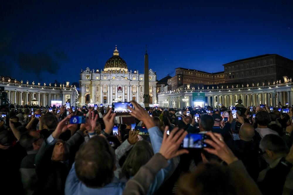 Fieles reunidos en la Plaza de San Pedro, en El Vaticano, usan sus teléfonos móviles para captar la fumata negra que sale de la chimenea de la Capilla Sixtina. FOTO: EFE