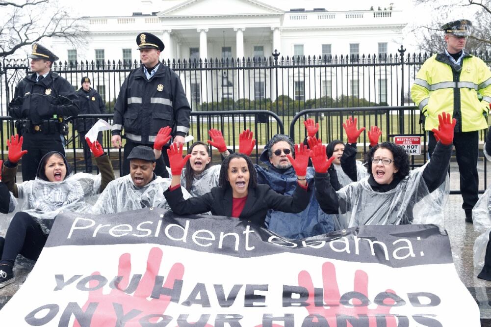 Activistas del Center Community Change, durante la protesta de ayer frente a la Casa Blanca. El cartel dice: "Obama, tienes las manos manchadas de sangre" (LENIN NOLLY. EFE)