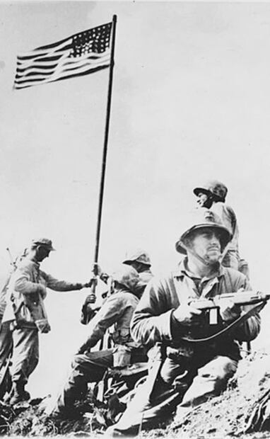 Aunque las dos fotos de la bandera de Estados Unidos en la cima del Monte Suribachi se tomaron el mismo día, la primera muestra una bandera de dimensiones menores y con sólo tres soldados que la sostienen. Foto: Louis R. Lowery/Library of Congress.