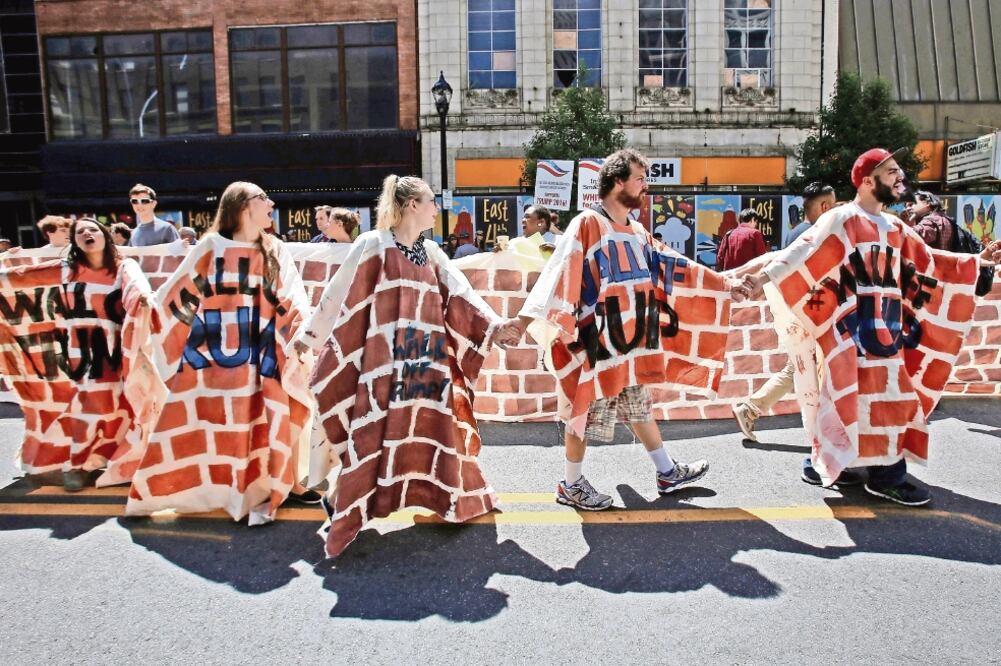 Activistas ataviados con ponchos que simulan muros participaron ayer en una protesta en favor de los derechos de los migrantes, en Cleveland (ANDREW KELLY. REUTERS)