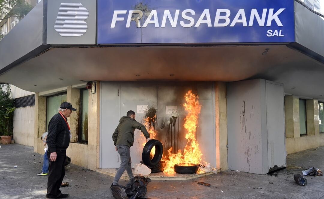 Los clientes del banco queman neumáticos fuera de FransaBank durante una protesta organizada por Depositors' Outcry, en el barrio de Badaro, Beirut. FOTO: EFE