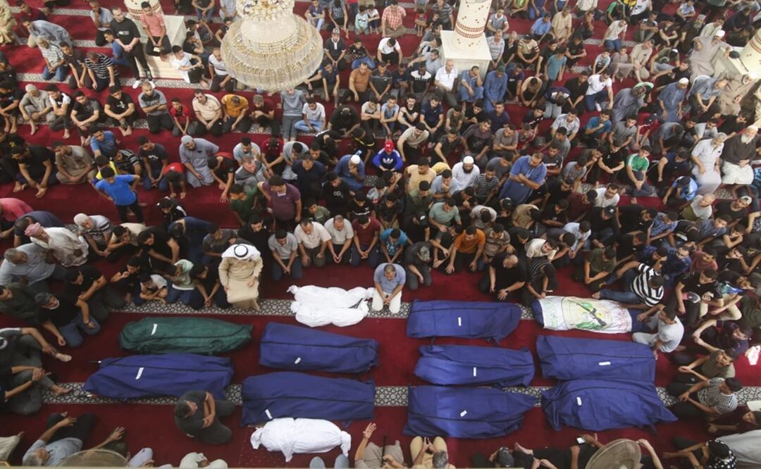 Dolientes rezan junto a los cadáveres de los familiares de Salem Abu Quta, combatiente de Hamás, durante un funeral. Foto: AP