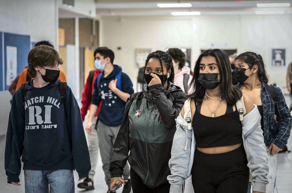 Jóvenes usan cubrebocas en un centro académico en los EU. Foto: AP / Mark Lennihan