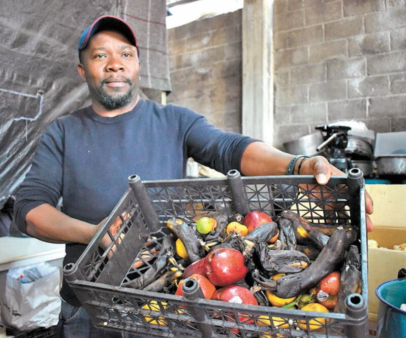 Uno de los migrantes que labora en el albergue en Metepec muestra el estado de las frutas y pan que envía el Banco de Alimentos del Estado de México. CLAUDIA GONZÁLEZ. ELUNIVERSAL