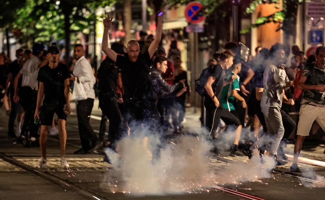 Los manifestantes huyen de una explosión de fuegos artificiales en una calle de Niza, sureste de Francia. Foto: AFP