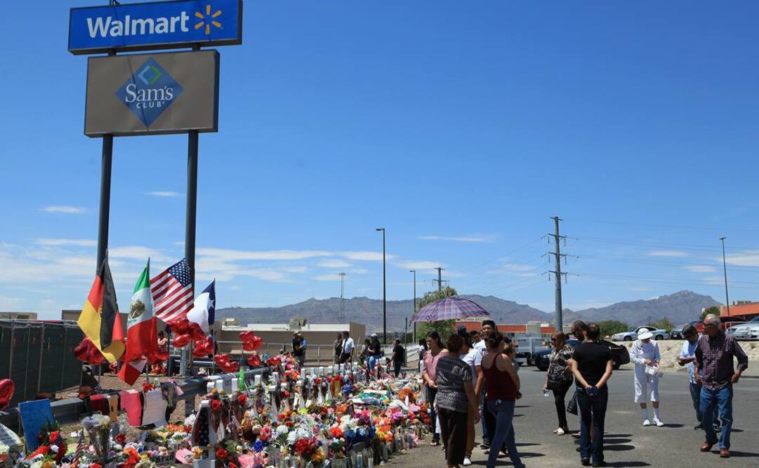 Personas caminan frente a ofrendas para las víctimas del ataque en un centro comercial de El Paso, en Texas. Foto: EFE