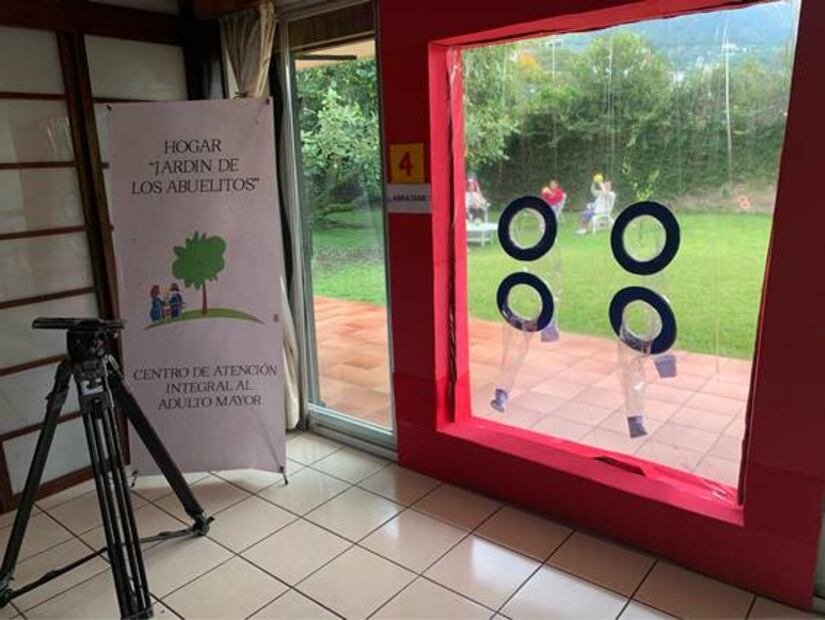 Con “cortina de abrazos”, acercan a abuelitos con sus familias en El Salvador