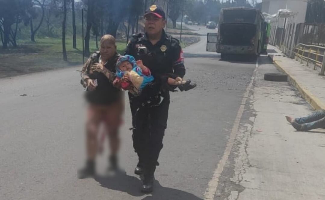 Mujer con quemaduras camina sobre el asfalto junto a policía que carga a bebé tras explosión de pipa de gas en Puente de la Concordia, Iztapalapa.  (10/09/2025). Foto: Especial
