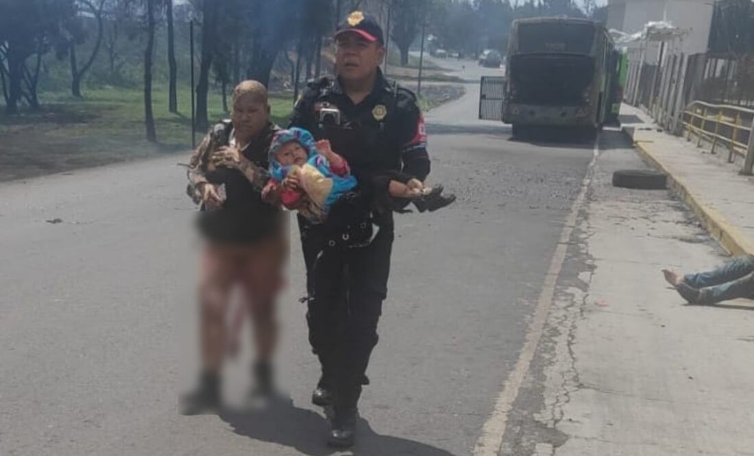 Mujer con quemaduras camina sobre el asfalto junto a policía que carga a bebé tras explosión de pipa de gas en Puente de la Concordia, Iztapalapa (10/09/2025). Foto: Especial