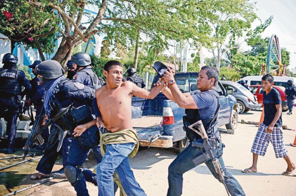 Un miembro de la Coordinadora Regional de Autoridades Comunitarias (CRAC) es arrestado por policías locales tras los enfrentamientos en Acapulco, Guerrero. (AFP)