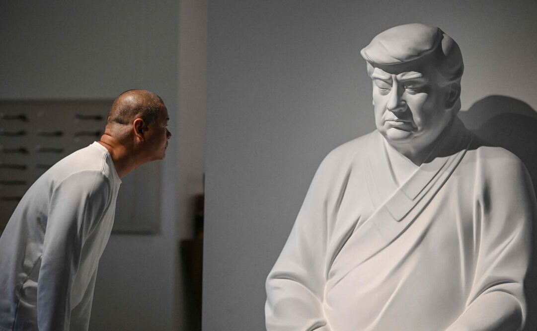 Esta foto tomada el 9 de diciembre de 2024 muestra al artista Hong Jinshi mirando una escultura del presidente electo de Estados Unidos, Donald Trump, en una pose que evoca a Buda en su taller en Xiamen, en la provincia de Fujian, en el sureste de China. Foto: AFP