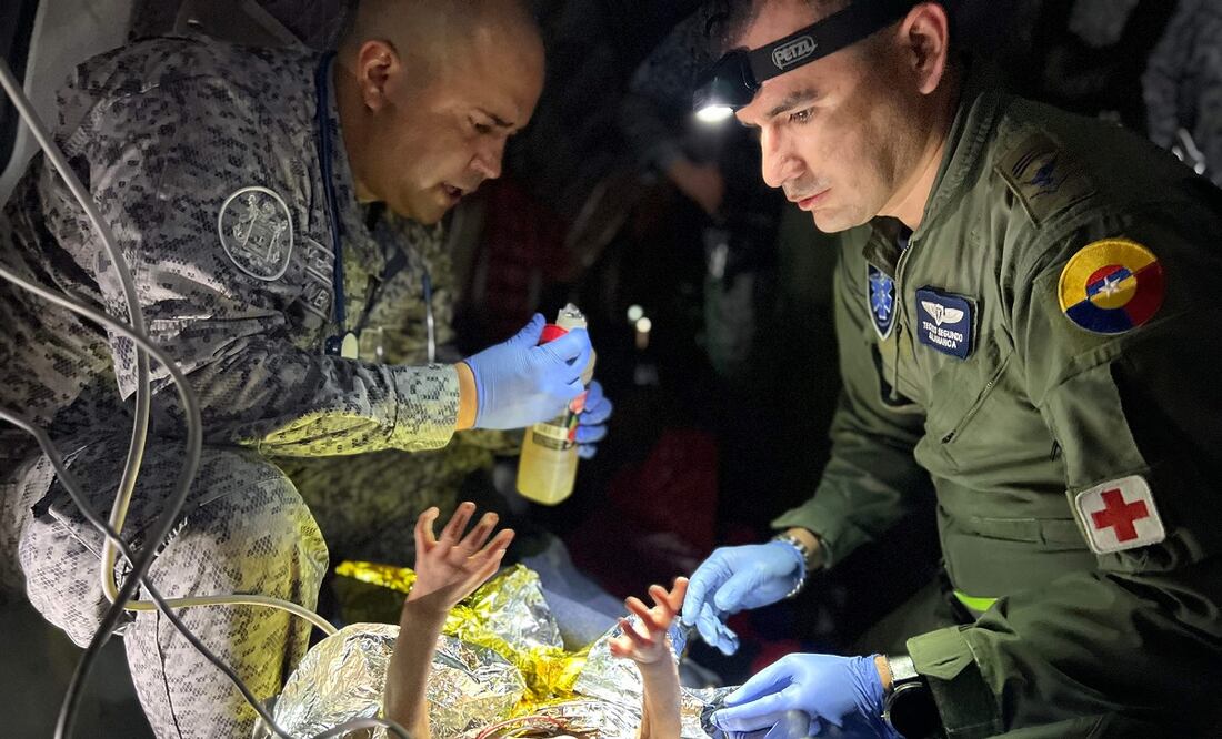 Soldados checan el estado de uno de los niños rescatados en la selva colombiana, en esta foto distribuida por la Presidencia de Colombia. FOTO: AFP