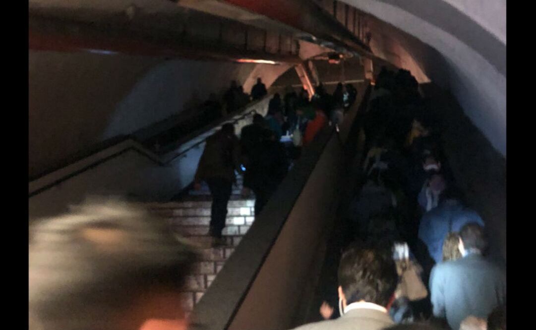 Persona de Protección Civil con lámparas y megáfonos apoyan a usuarios del sistema a salir de la estación. FOTO: @Mammalueke