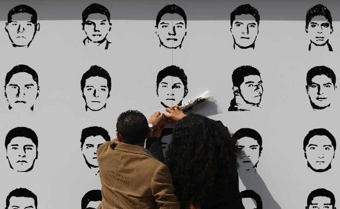People attach flowers to a mural showing the faces of the 43 missing Ayotzinapa students – Photo: Bernardo Montoya/REUTERS 