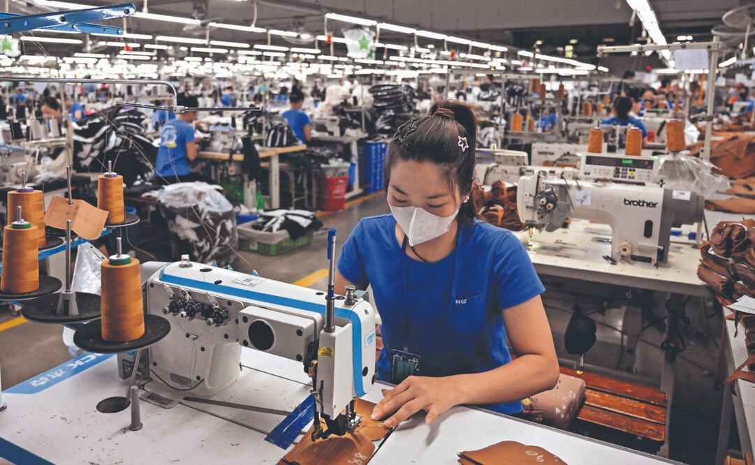 Empleada en una fábrica textil en Thai Nguyen, Vietnam, un centro manufacturero global que depende de las exportaciones. Foto: de NHAC NGUYEN. AFP