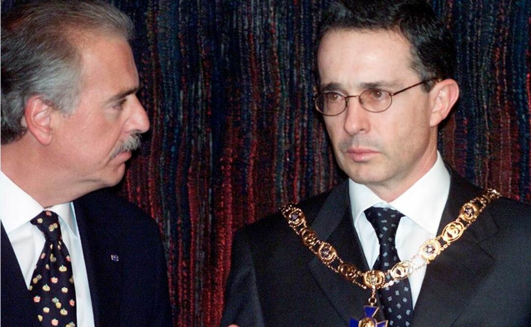 En esta foto de archivo del 5 de agosto de 2002, el entonces presidente Andrés Pastrana, izquierda, mira al entonces presidente electo Álvaro Uribe durante una ceremonia en el palacio presidencial de Bogotá, Colombia. (AP Foto/Ricardo Mazalan)