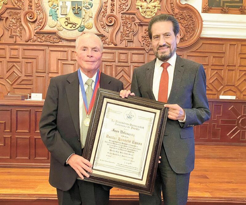 Juan Velásquez Evers (izq.) recibió el doctorado de manos del rector de la BUAP, Alfonso Esparza. Foto: Especial