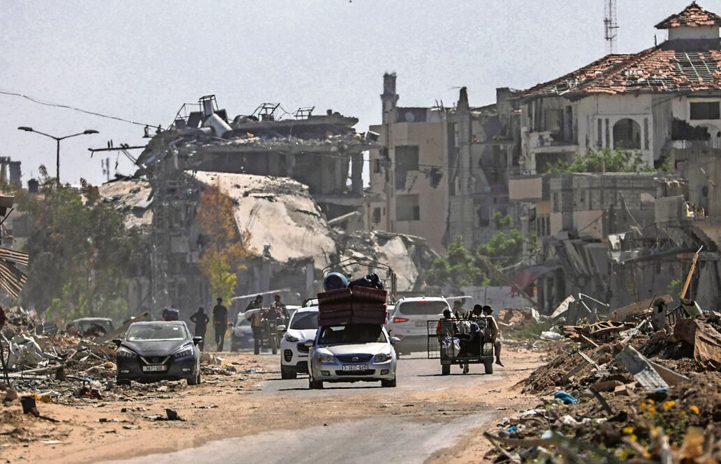 Palestinos desplazados pasan junto a edificios destruidos, al abandonar el sur de Rafah tras las advertencias de Israel de que atacaría la zona. Foto: EFE