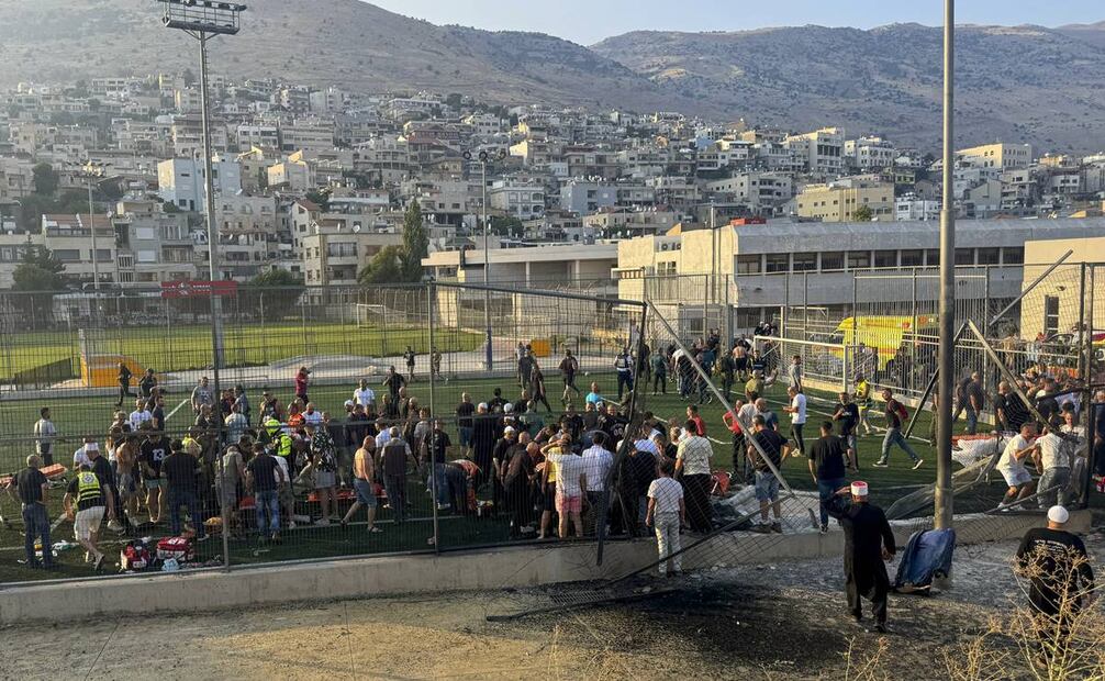Habitantes y paramédicos socorren a víctimas momentos después de que un cohete cayera en un campo de fútbol en la ciudad drusa de Majdal Shams, en los Altos del Golán. Foto: AP