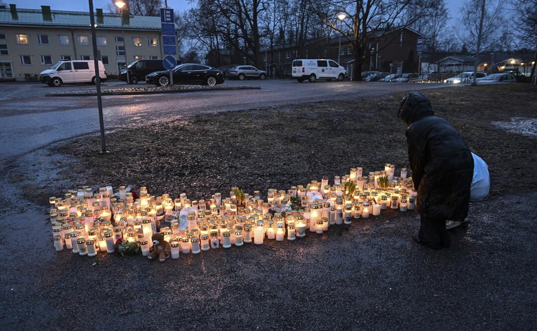 Afuera de la escuela, varias personas desafiaron el frío y la nieve para depositar flores, velas y peluches en memoria de la víctima. Foto: EFE