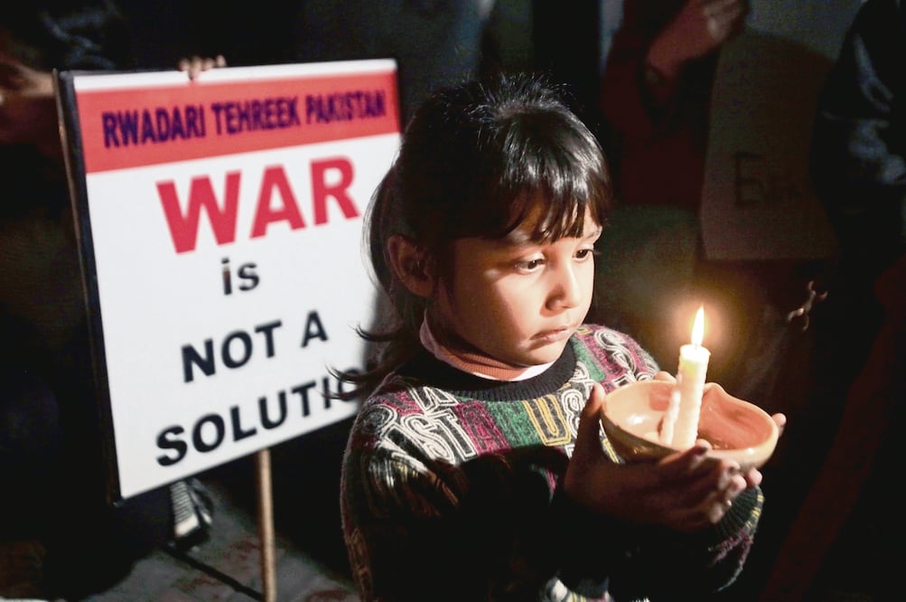 Una niña participa, con otros, en la vigilia de paz, en Lahore, Paquistán 