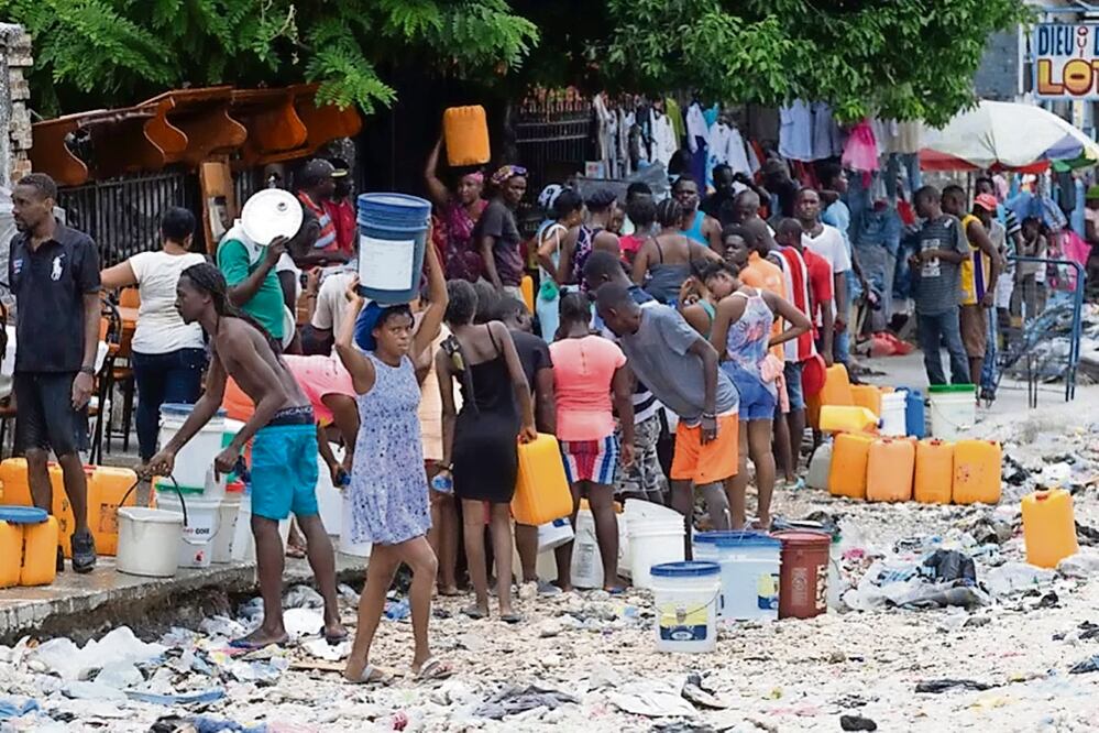 Haitianos recolectan agua en Puerto Príncipe; apenas 24% de los casi 12 millones de habitantes lograron contar con el líquido proveniente de estructuras sometidas a saneamiento, de acuerdo con el Banco de
Desarrollo de América Latina y el Caribe. Foto: Orlando Barría EFE