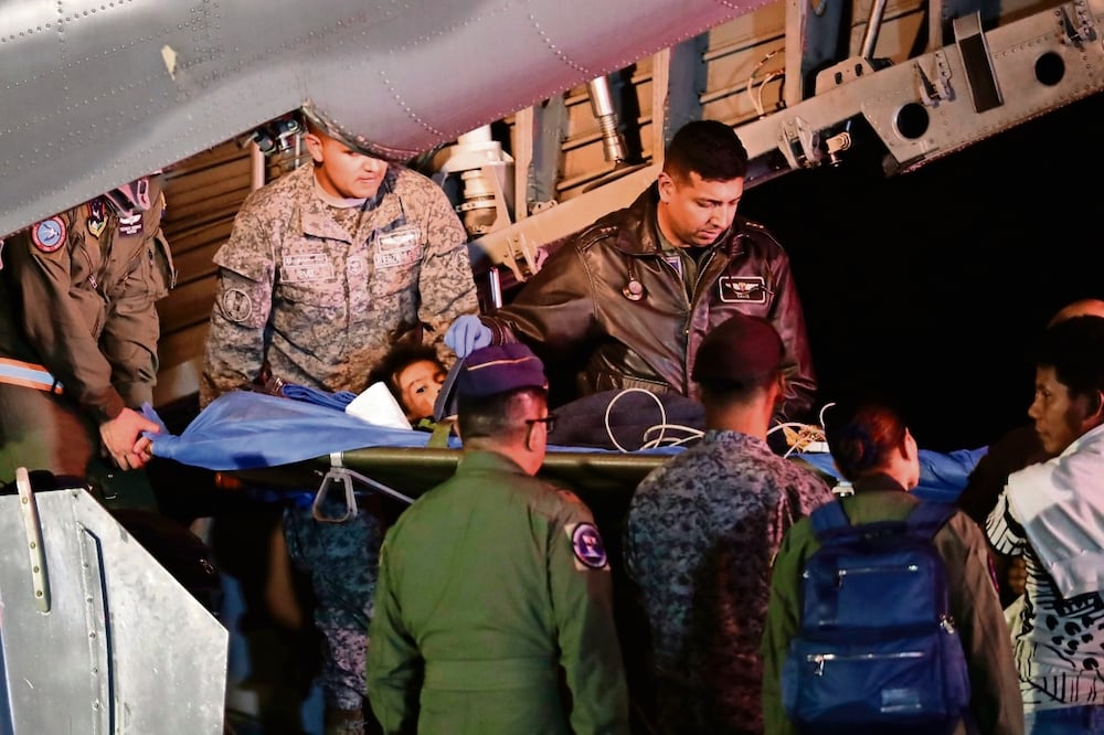 Personal militar, el sábado pasado al bajar de un avión en Bogotá a uno de los cuatro niños indígenas que estuvieron desaparecidos en la Amazonia colombiana. Foto: Ivan Valencia / AP