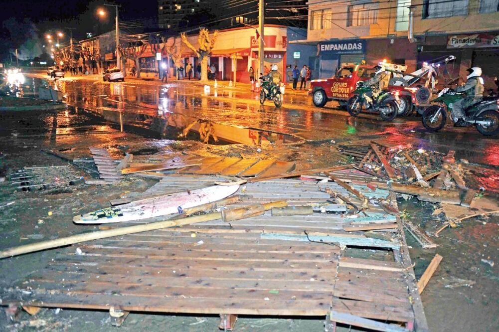 La policía sigue el curso de escombros arrastrados por el tsunami en una calle de Valparaíso, tras el sismo de 8.4 que sacudió ayer la costa norte de Chile, obligando al desalojo de varios miles de personas en el área (PABLO OVALLE ISASMENDI. AP)