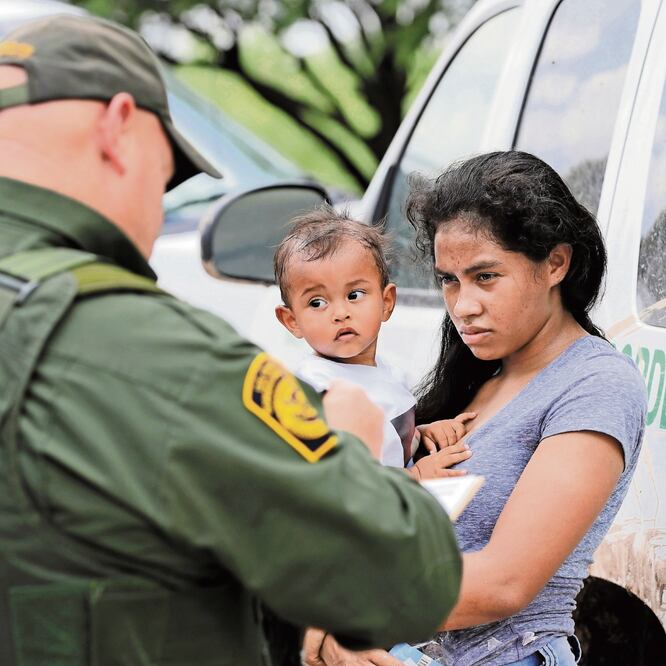 Una migrante hondureña con su hijo de un año, frente a un agente de la Patrulla Fronteriza, en McAllen, Texas, en una imagen de junio de 2018. AP. ARCHIVO