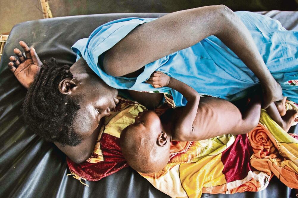 Imagen de octubre de 2016 en la que una madre alimenta a su hijo con desnutrición en Sudán del sur, donde ayer fue declarada la emergencia por hambruna (ALBERT GONZALEZ FARRAN. AFP)